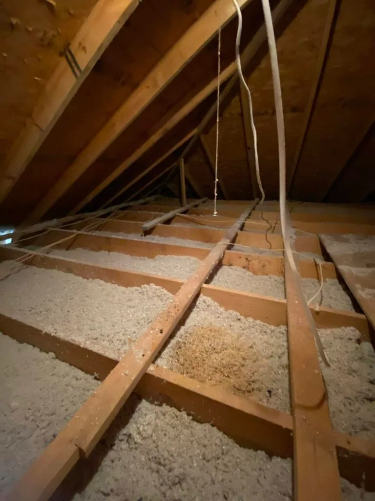 Attic space with blown-in insulation, ceiling joists, and line set wiring routed to prepare for HVAC installation, West