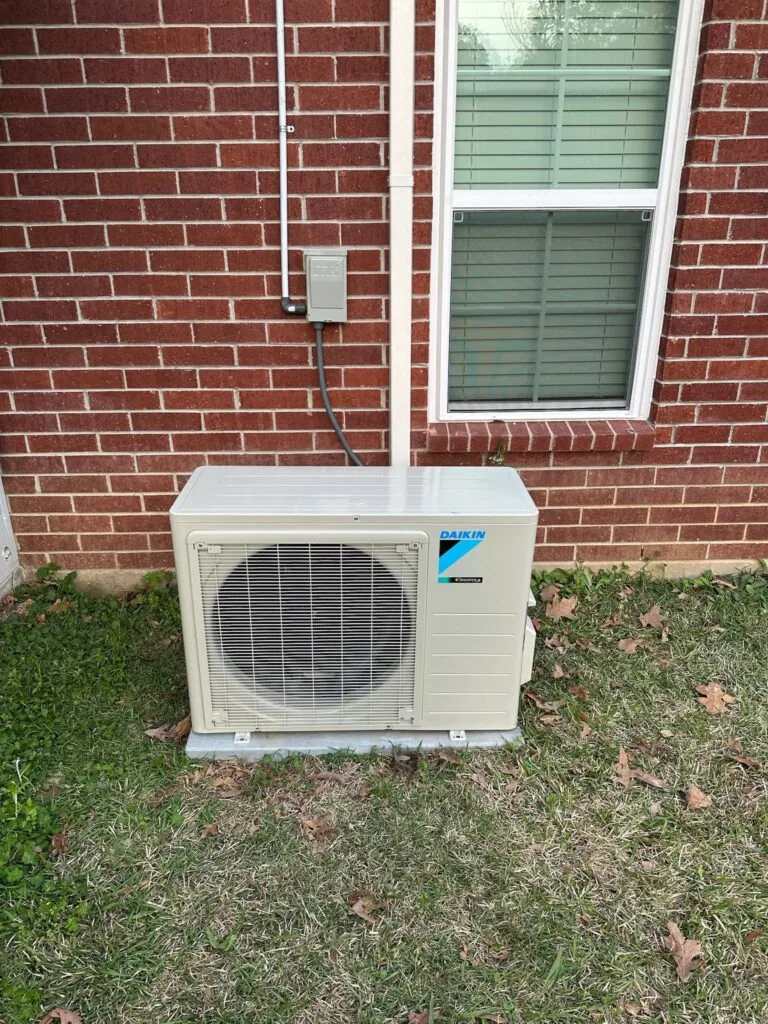 Daikin ductless heat pump condenser unit installed outside a brick house in West Monroe, LA