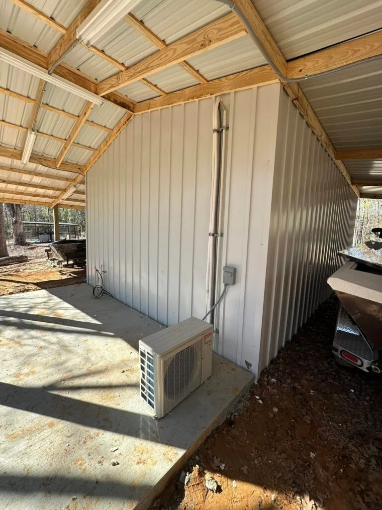 Ductless mini split condenser unit on concrete pad beside a metal pole barn in West Monroe, LA