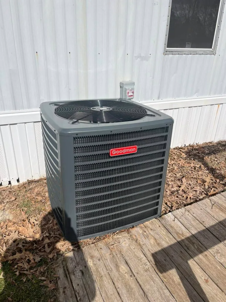 Goodman condenser unit on a wood deck next to a metal-sided mobile home in West Monroe, LA
