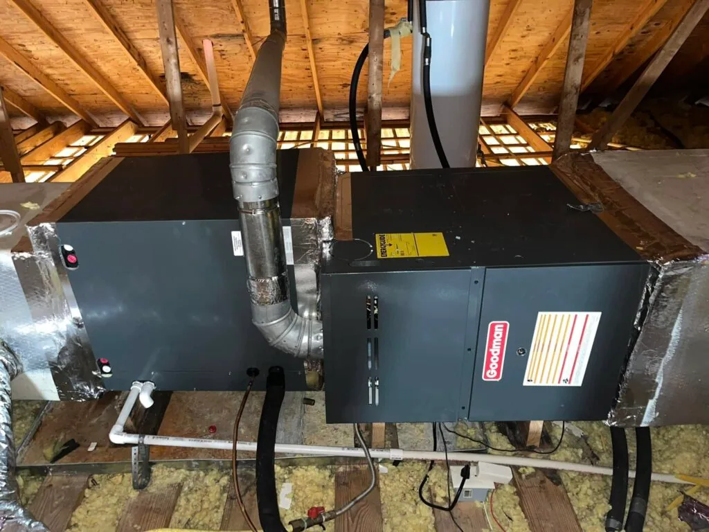 Goodman furnace and air handler installed in a home attic with vent piping and insulation in West Monroe, LA