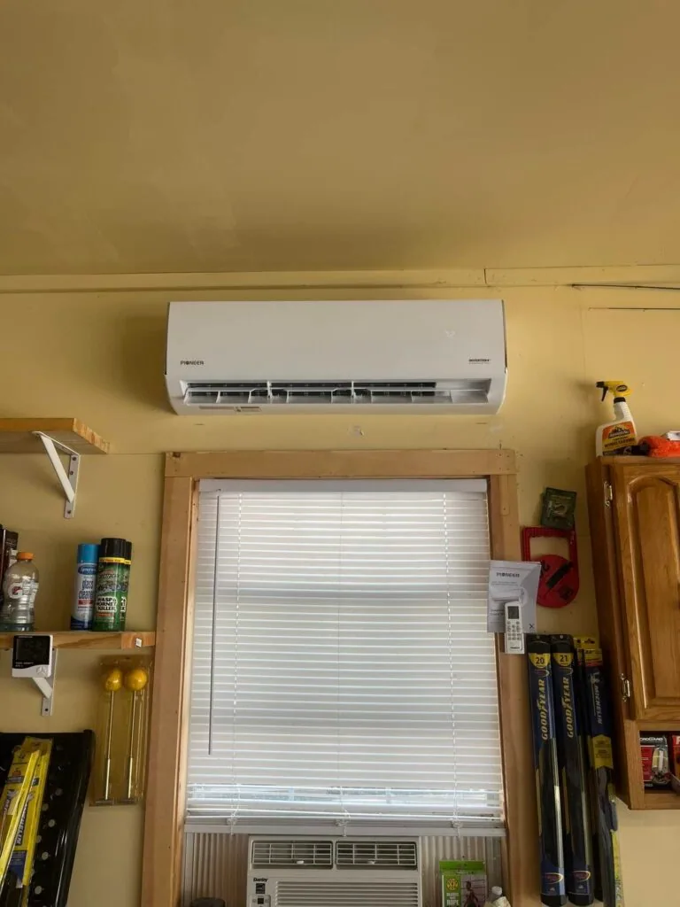 White Pioneer ductless mini split indoor unit mounted above a window in a garage in West Monroe, LA