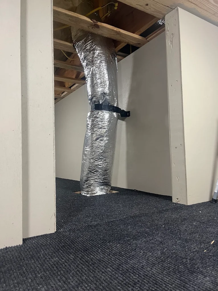 Insulated flexible ductwork running through an attic space between two knee walls