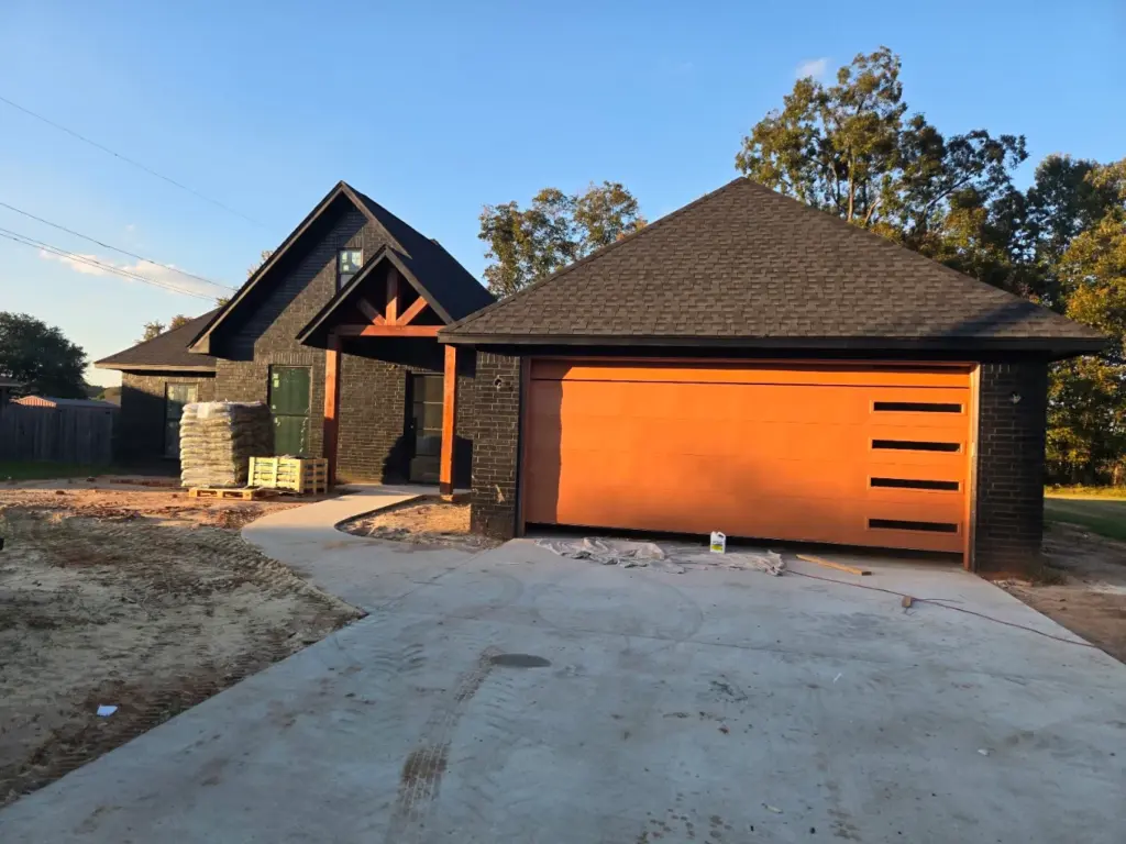 New construction brick home with garage and unfinished driveway, site for HVAC installation in West Monroe, LA